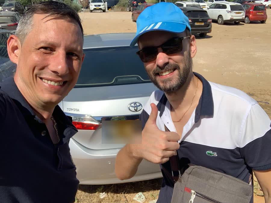 בני עם לקוח ליד הרכב שנבחר ונבדק